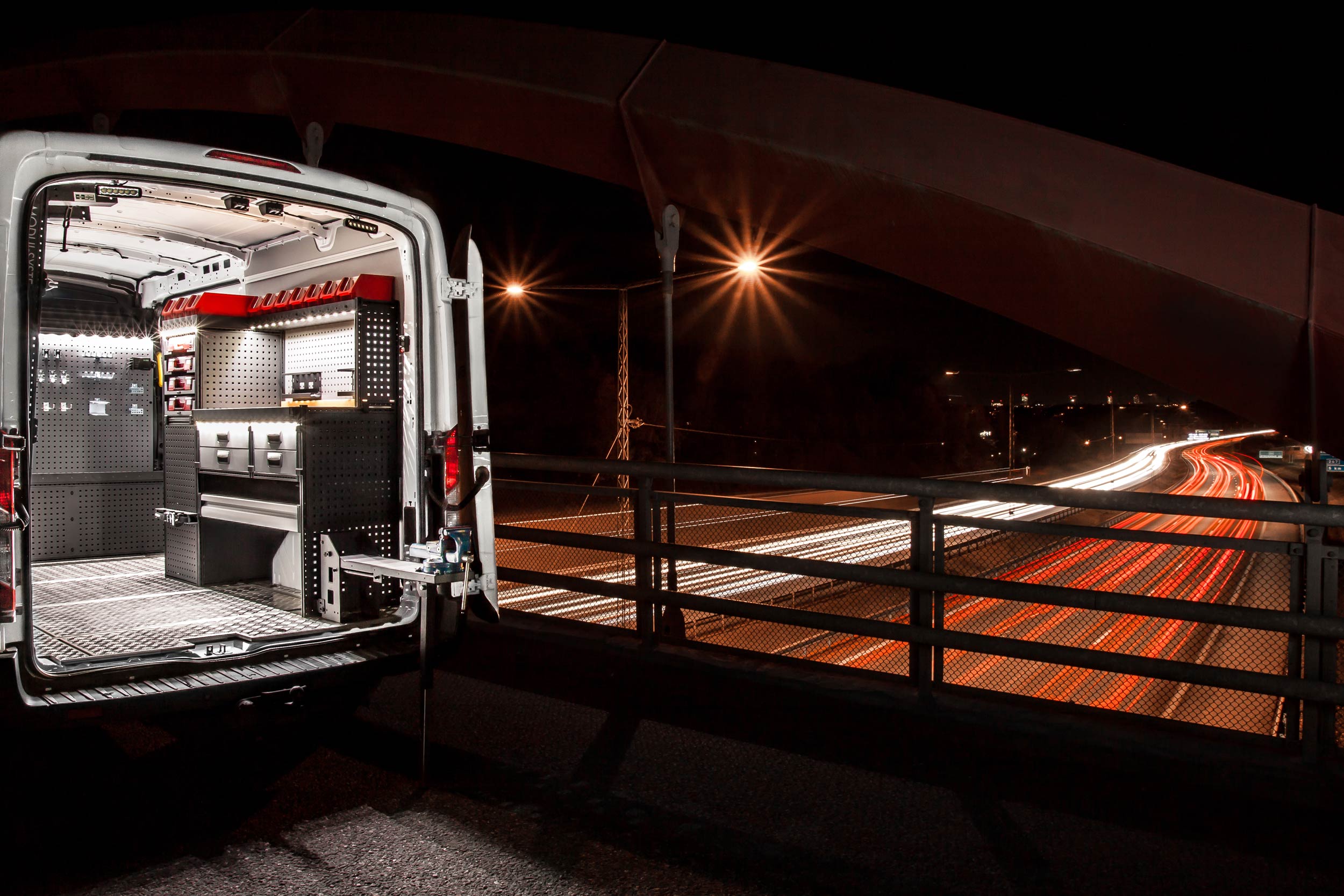 Electrician's van fitted out with modul-system van racking on the job at night